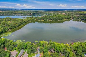 Eine Vogelperspektive auf einen See, umgeben von dichter Vegetation und Wohngebäuden.