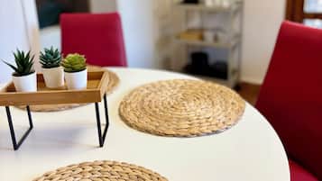 A dining area with a white table, red chairs, and woven placemats.