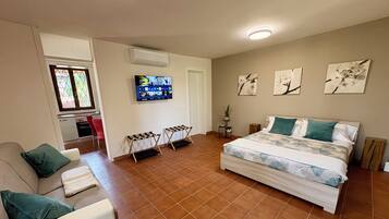 Une chambre à coucher avec un lit, une télévision, un bureau et une chaise.