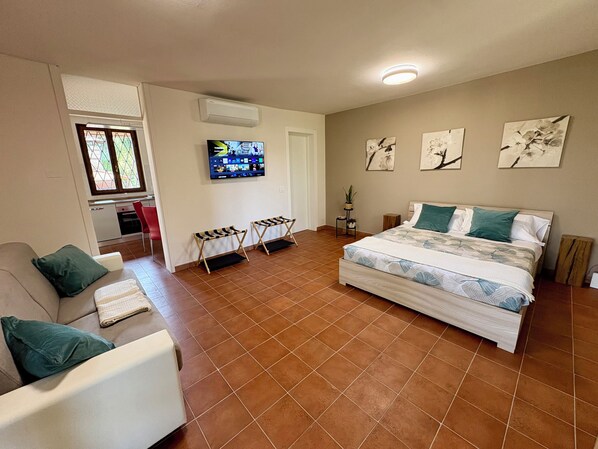 Un dormitorio con cama, televisor, escritorio y silla.