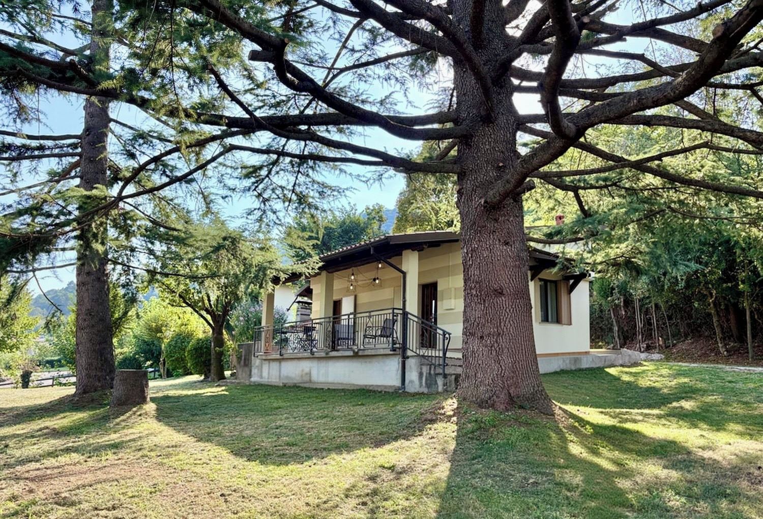 Una casa con un portico, circondata da alberi.