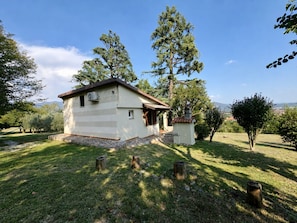 Un petit bâtiment d’un seul étage, doté d’un toit plat et entouré de pelouse et d’arbres.