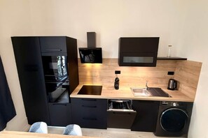 A compact kitchen with a dishwasher, sink, and a microwave. - Apartment near Parc Fenestre (La Bourboule)