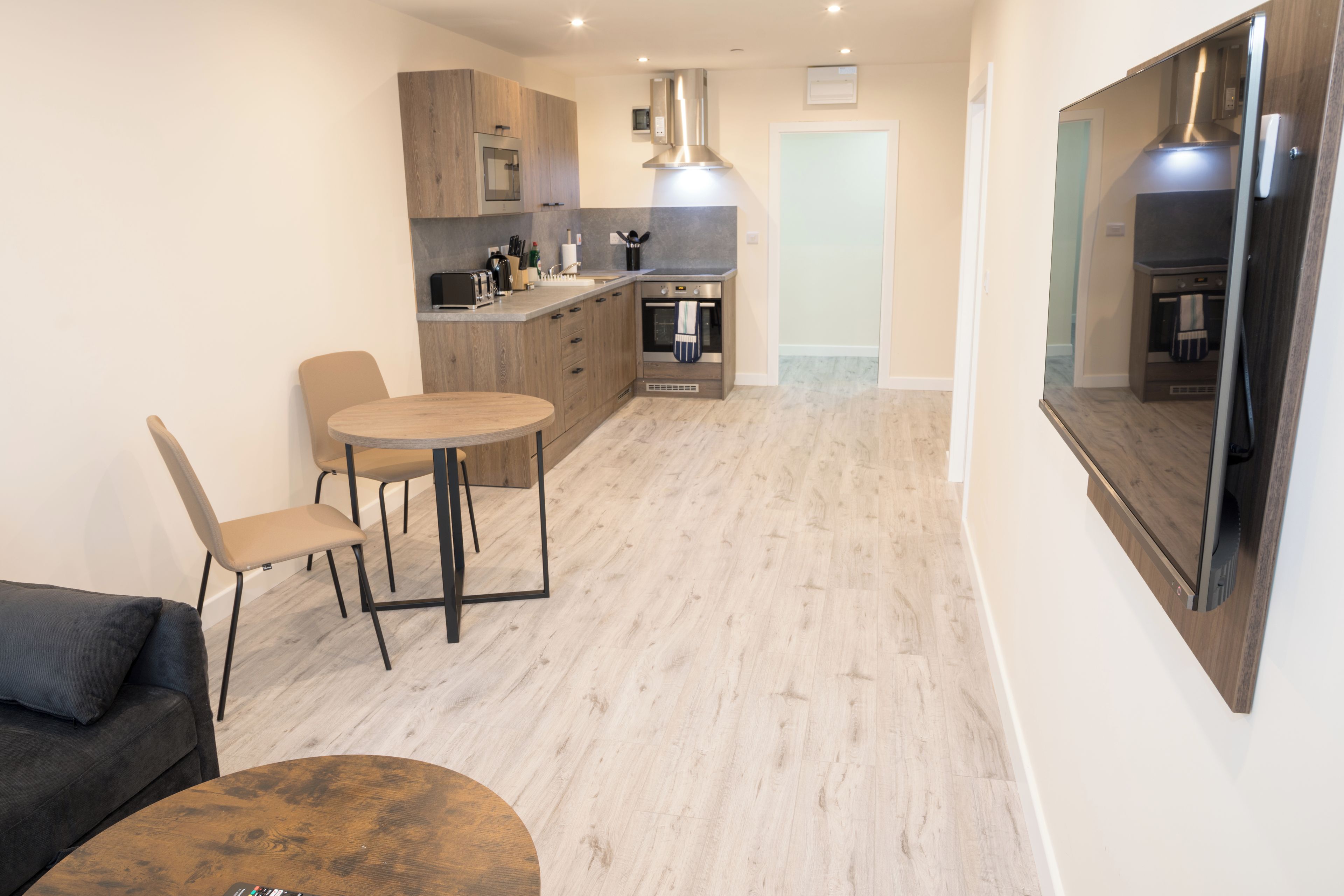 A compact kitchen with a dining area, a sofa, and a coffee table.