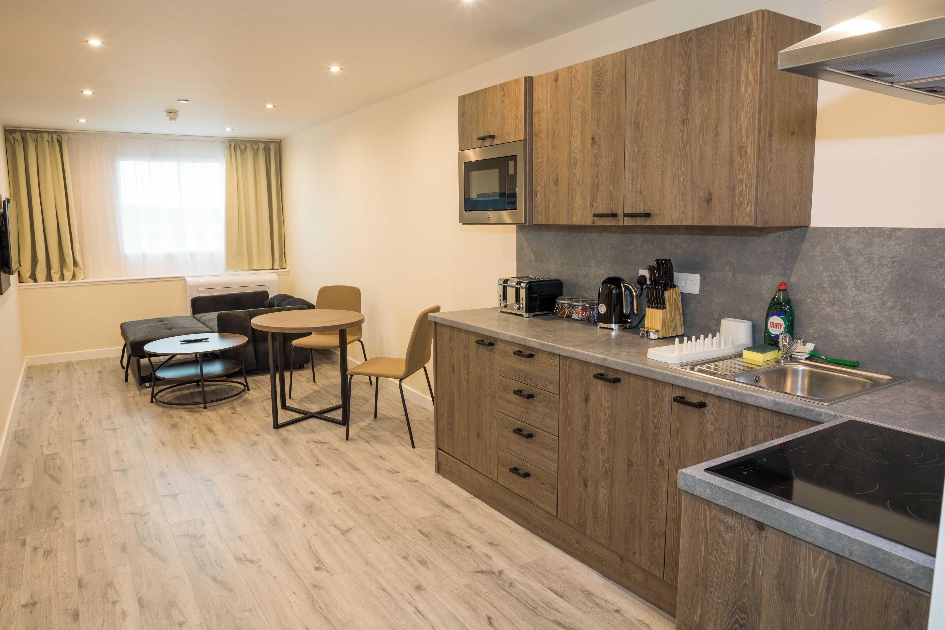 A modern kitchen with wooden cabinets, a built-in microwave, and a gas stove.