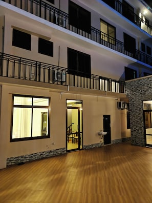 Un hotel de varios pisos con recepción, una escalera y un balcón.
