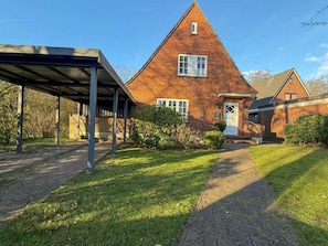 A brick house with a covered porch, a front door, and a small window. - "holidays in a Former Captain's House" (Wyk auf Foehr)