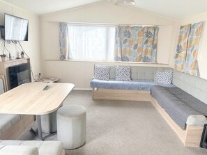 Ein gemütliches Wohnzimmer mit Sofa, Tisch und Fernseher.