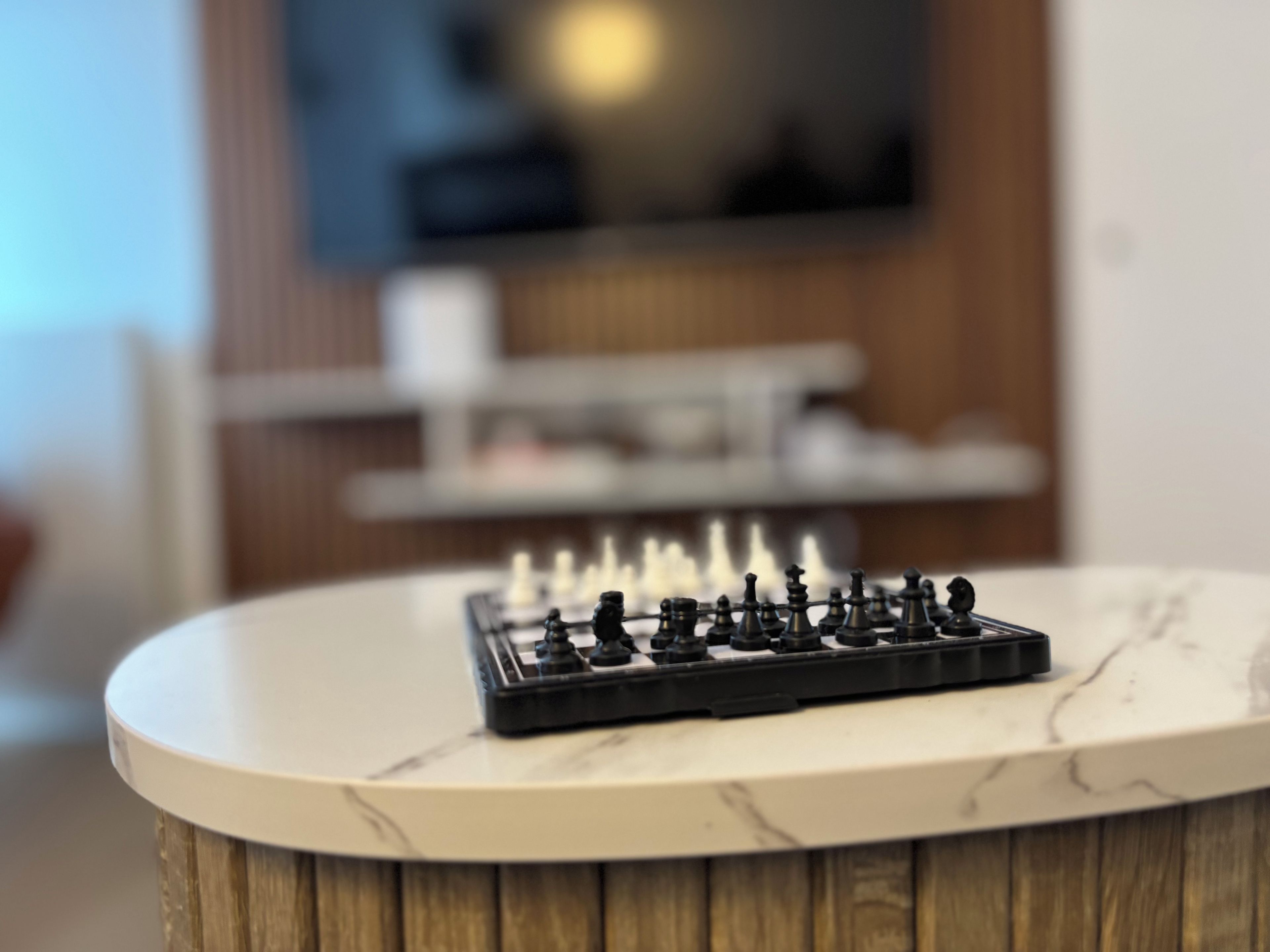 A chessboard on a marble table with a blurred background.