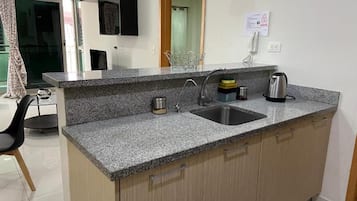 A kitchen with granite countertops, a stainless steel sink, and wooden cabinets.