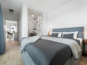 A modern bedroom with a large bed, a bedside table, and a nightstand. - Apartment in Olpenitz With Swimming Pool (Kappeln)