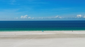 Ein Strand mit blauem Himmel und ruhiger See.