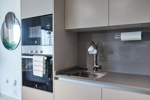 A modern kitchen with a built-in oven, a stainless steel sink, and a towel rack. - Casa Hela - Large Terrace - Pool - Gym (Estepona)