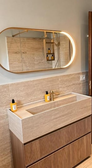 A bathroom with a large mirror, a wooden vanity, and a modern faucet. - Villa Angelina (PROVINCIA DI AREZZO)