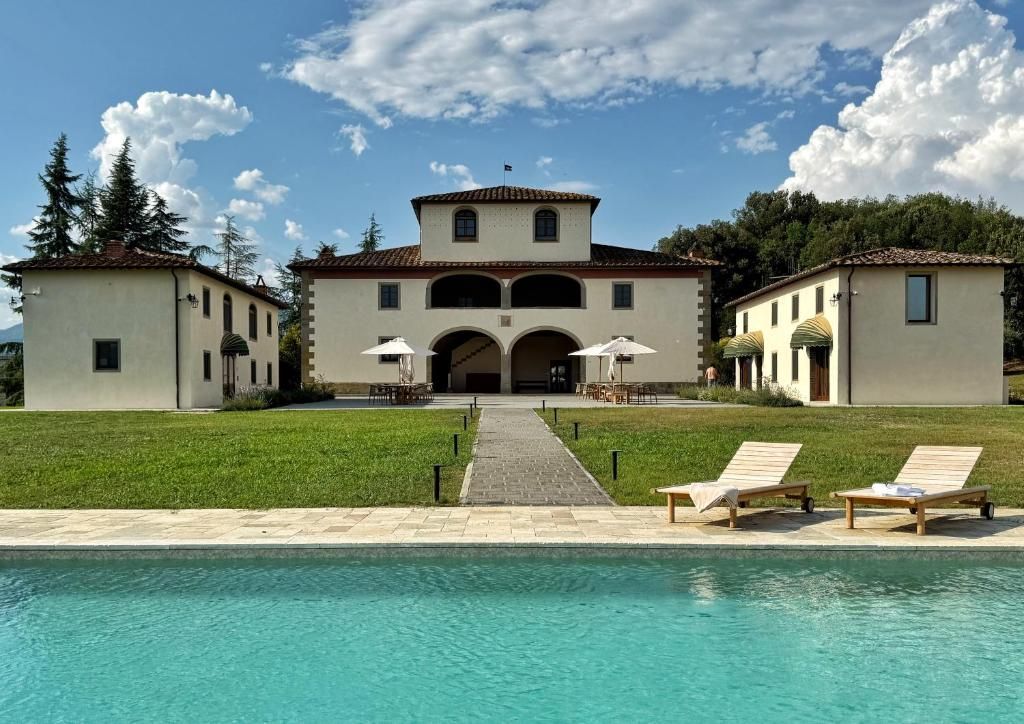 Un hotel con piscina, zona de estar exterior y un patio central.