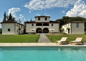 A hotel with a swimming pool, outdoor seating, and a central courtyard. - Villa Angelina (PROVINCIA DI AREZZO)