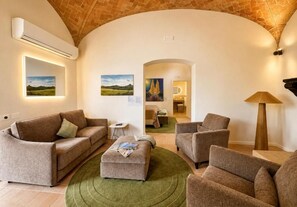 A living room with a brick ceiling, a sofa set, a coffee table, and artwork on the walls. - Villa Angelina (PROVINCIA DI AREZZO)