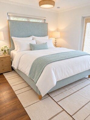 A neatly arranged bedroom with a bed, bedside tables, and a nightstand. - SHELL HOUSE - Old Florida Charm - Minutes to Historic Downtown Stuart & Beaches (Stuart)