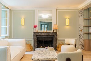 Una sala de estar con chimenea, asientos e iluminación en la pared.