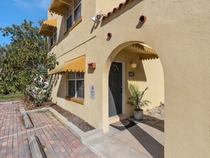 A building with a beige facade, a door with a small window, and a potted plant outside. - Lake Toho Haven | Vintage Boho Style & Park Views (Kissimmee)