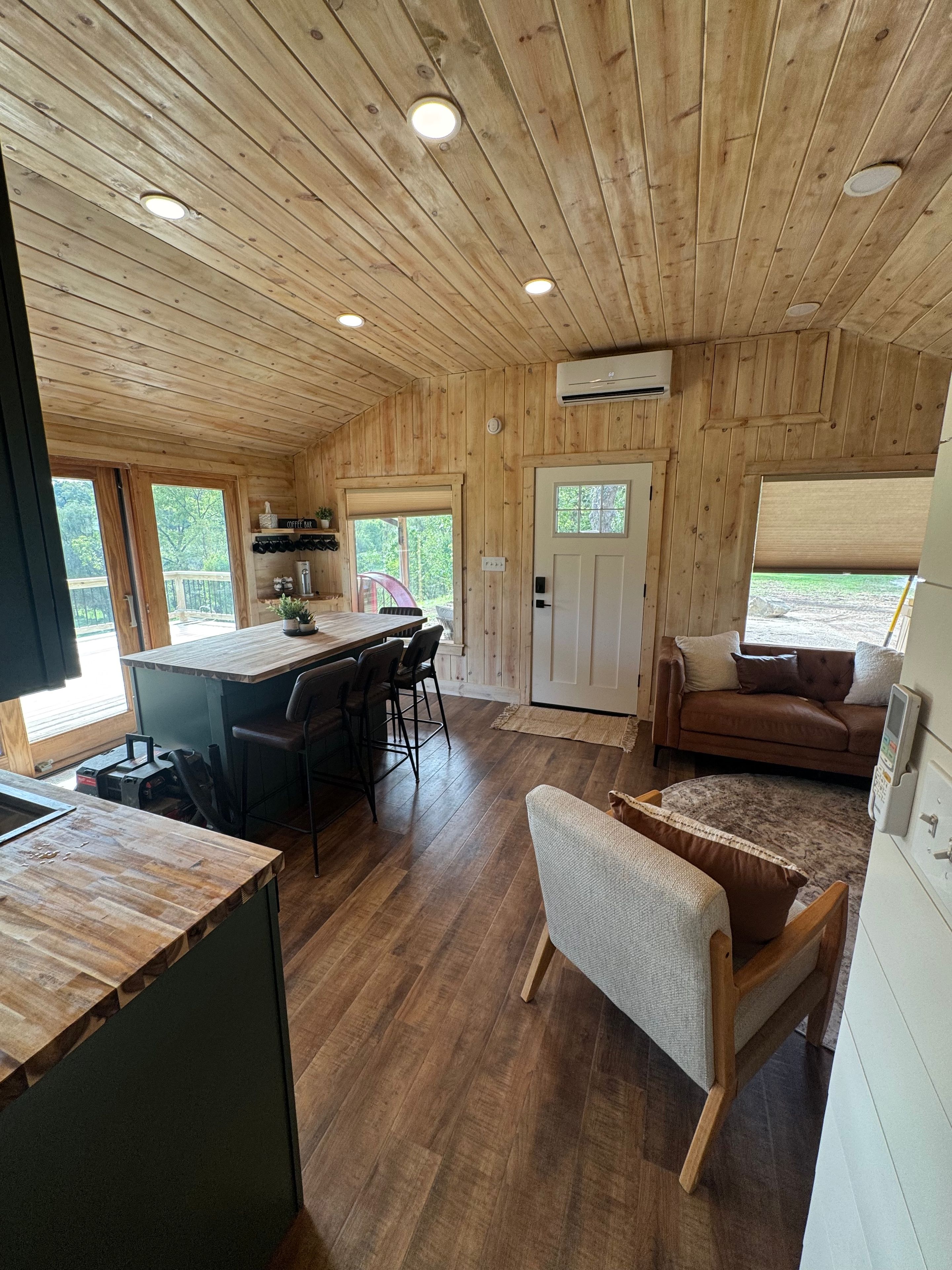 A wooden interior with a kitchen, dining area, and living space.