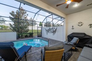 Ein Außenpoolbereich mit Glasveranda, Liegestühlen und Grillmöglichkeit.