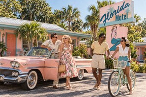 Un coche antiguo estacionado frente a un motel con un letrero que dice 'Florida Motel'.
