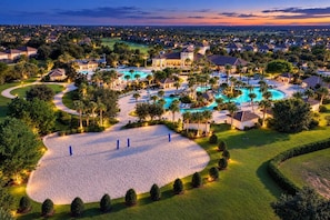 A resort with multiple swimming pools, well-maintained lawns, and a variety of buildings. - 4BR Champions Gate Villa | Oasis Club Amenitie’s (Kissimmee)