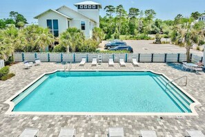 A rectangular swimming pool with a clear blue water, surrounded by a paved deck with lounge chairs and a fence. - 30A Upscale Villa | Coastal Charm & Beach Access (Santa Rosa Beach)