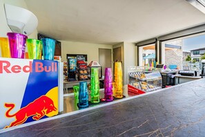A Red Bull kiosk with colorful cups and a display of baked goods. - Super Ritzy 9BR | Ultimate Disney Retreat (Orlando)