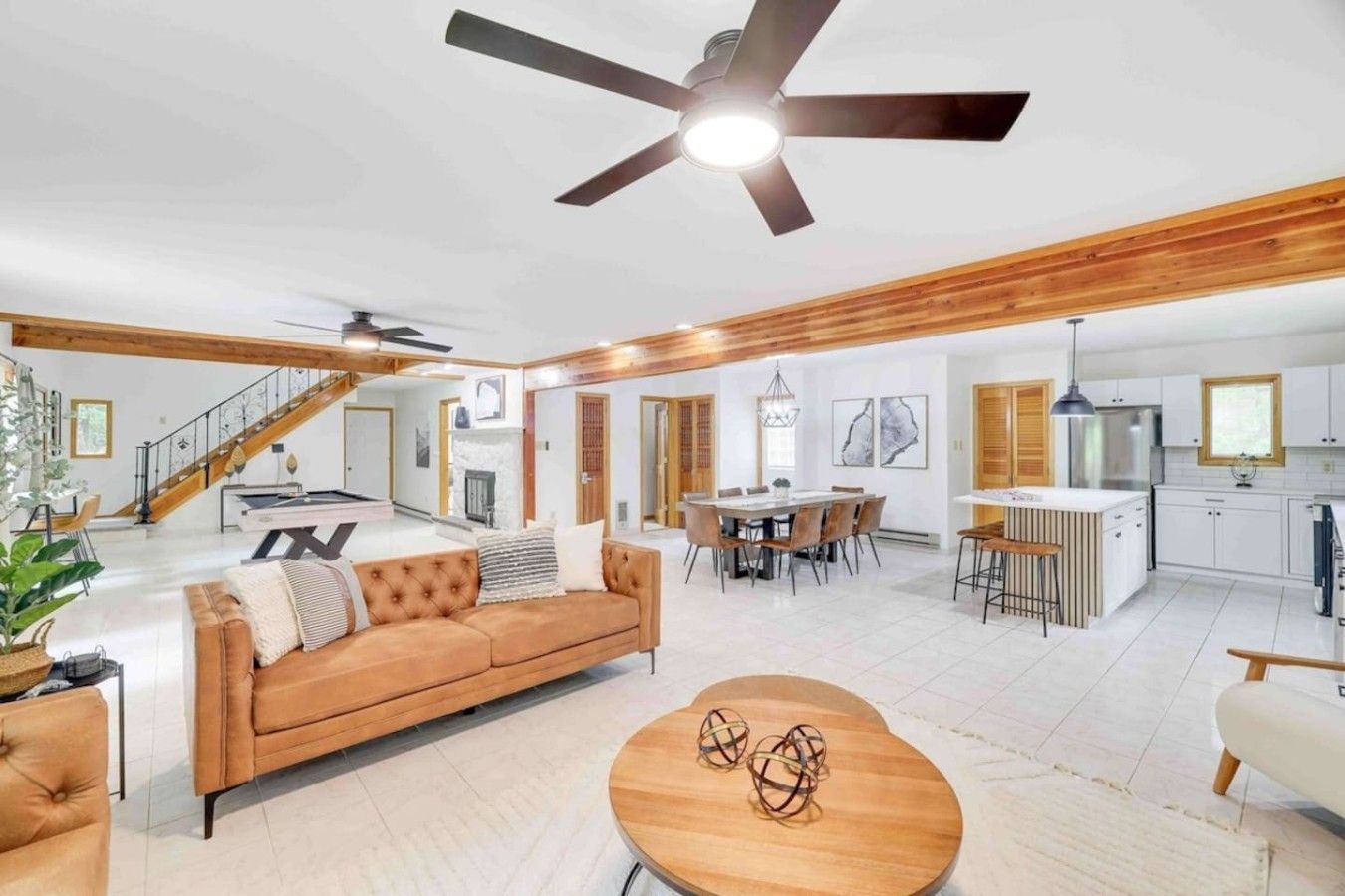 A spacious living area with a sofa, dining table, and a ceiling fan.