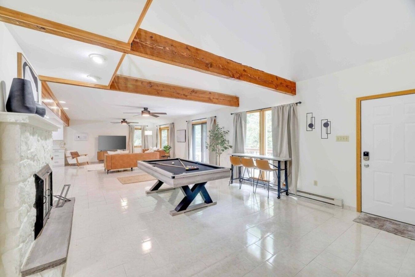 A spacious living area with a pool table, a fireplace, and a dining area.