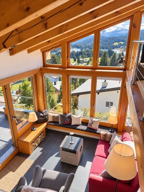 A room with large windows offering a view of a mountainous landscape. - Foppa Alpine Lodge – Ski-in/Ski-out & Sauna (Valbella)