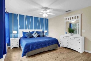 A bedroom with a bed, a white dresser, a ceiling fan, and a window with curtains. - Regal Palms Villa | Lazy River | Slides | Arcade | (Davenport)