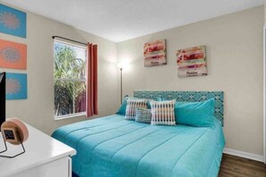 A bedroom with a bed, a desk, a window with curtains, and wall decorations. - Regal Palms Villa | Lazy River | Slides | Arcade | (Davenport)