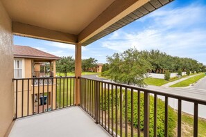 A balcony with a view of a residential street and houses. - Regal Palms Villa | Lazy River | Slides | Games (Davenport)