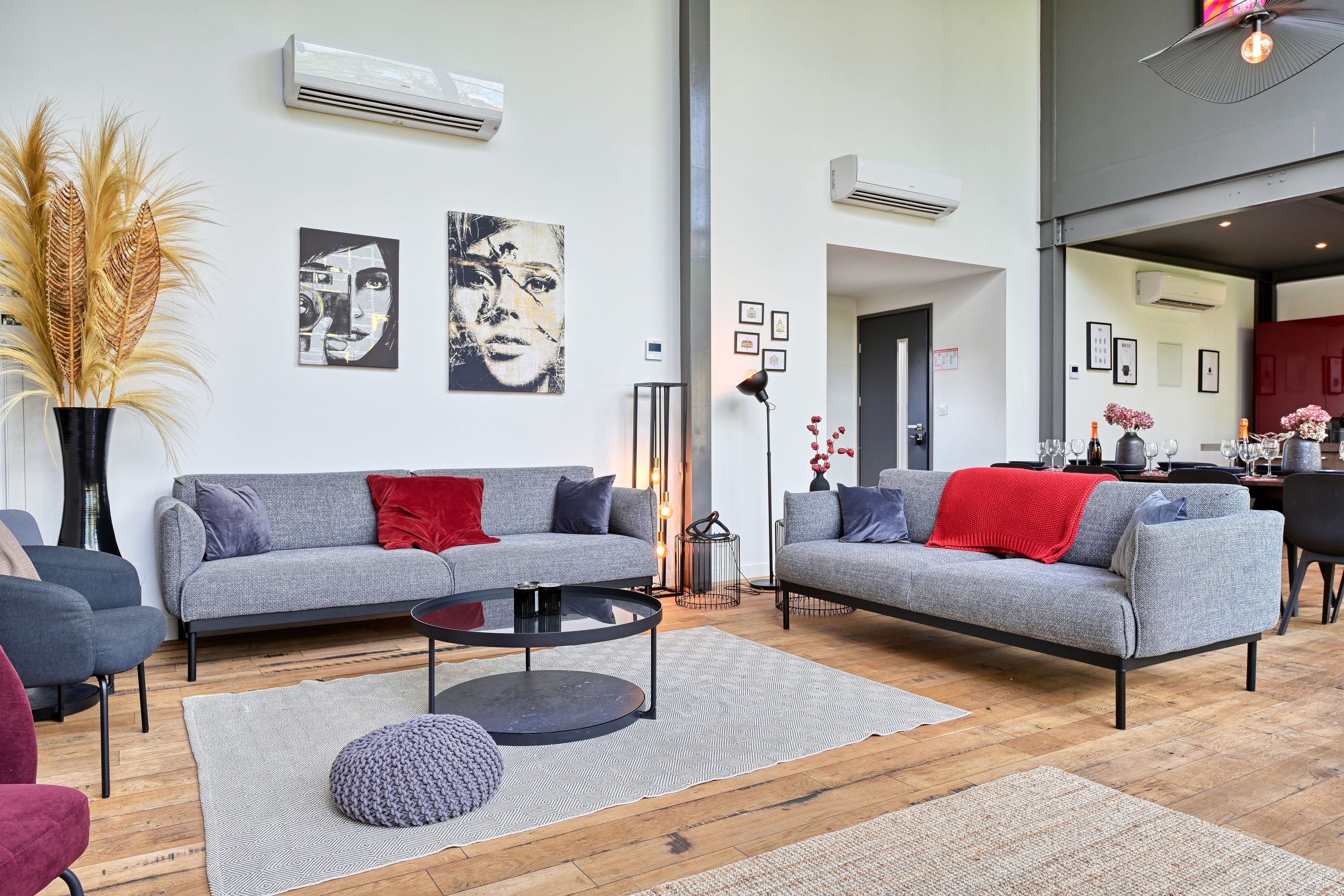 A modern living room with two grey sofas, a round coffee table, and a large window.