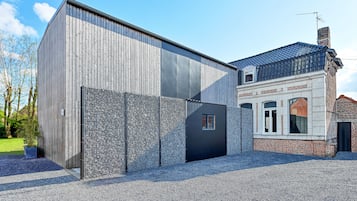 Ein modernes Gebäude mit einer großen Metallfassade und einem traditionellen Backsteinbau mit Ziegeldach.