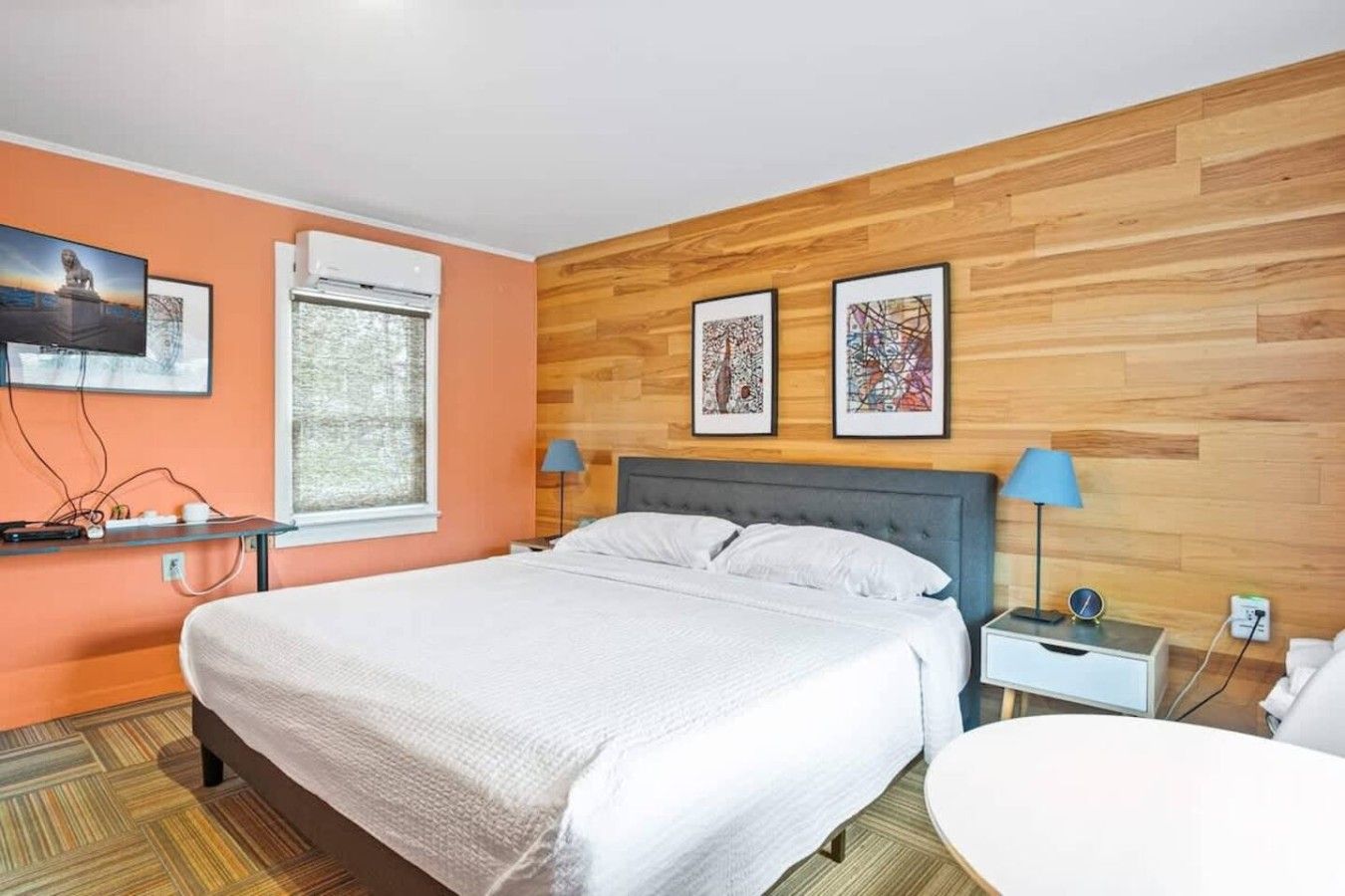 A hotel room with a bed, bedside tables, a desk, and a chair.