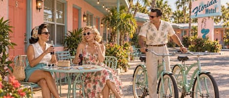 A vintage-style motel with outdoor seating and a bicycle.