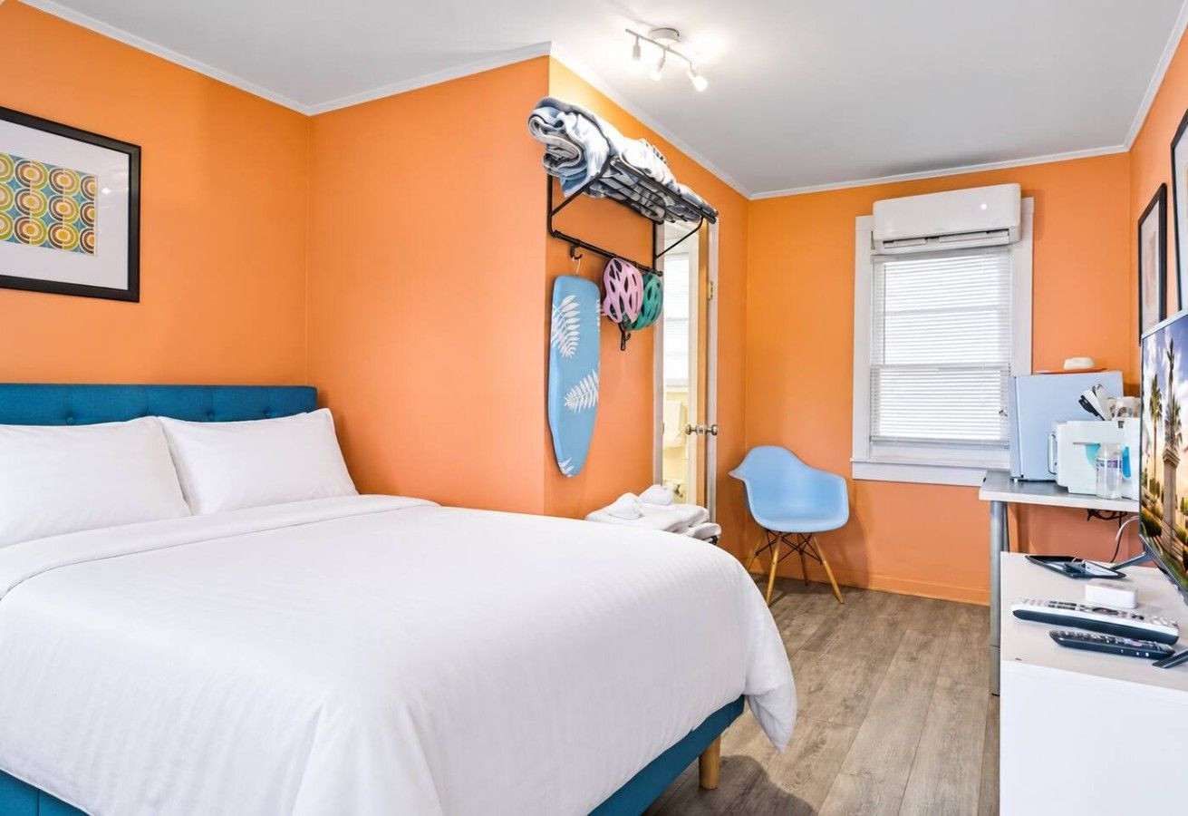 Ein Schlafzimmer mit Bett, Schreibtisch, Stuhl und Fenster.