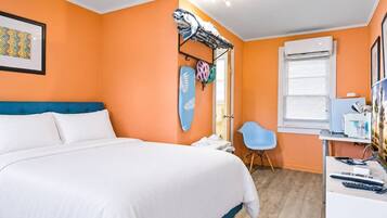 Ein Schlafzimmer mit Bett, Schreibtisch, Stuhl und Fenster.