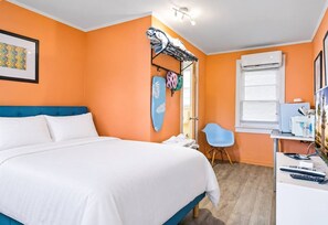 Ein Schlafzimmer mit Bett, Schreibtisch, Stuhl und Fenster.