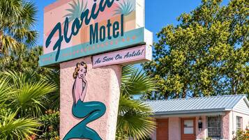 Schild eines Motels mit einer Meerjungfrau-Illustration und dem Text 'Florida Motel wie er im Fernsehen bei Atlets gesehen wurde'.