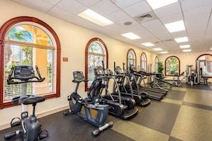 A gym with multiple treadmills, stationary bikes, and weight machines. - Regal Palms Villa | Sliding Fun | Arcade | River (Davenport)