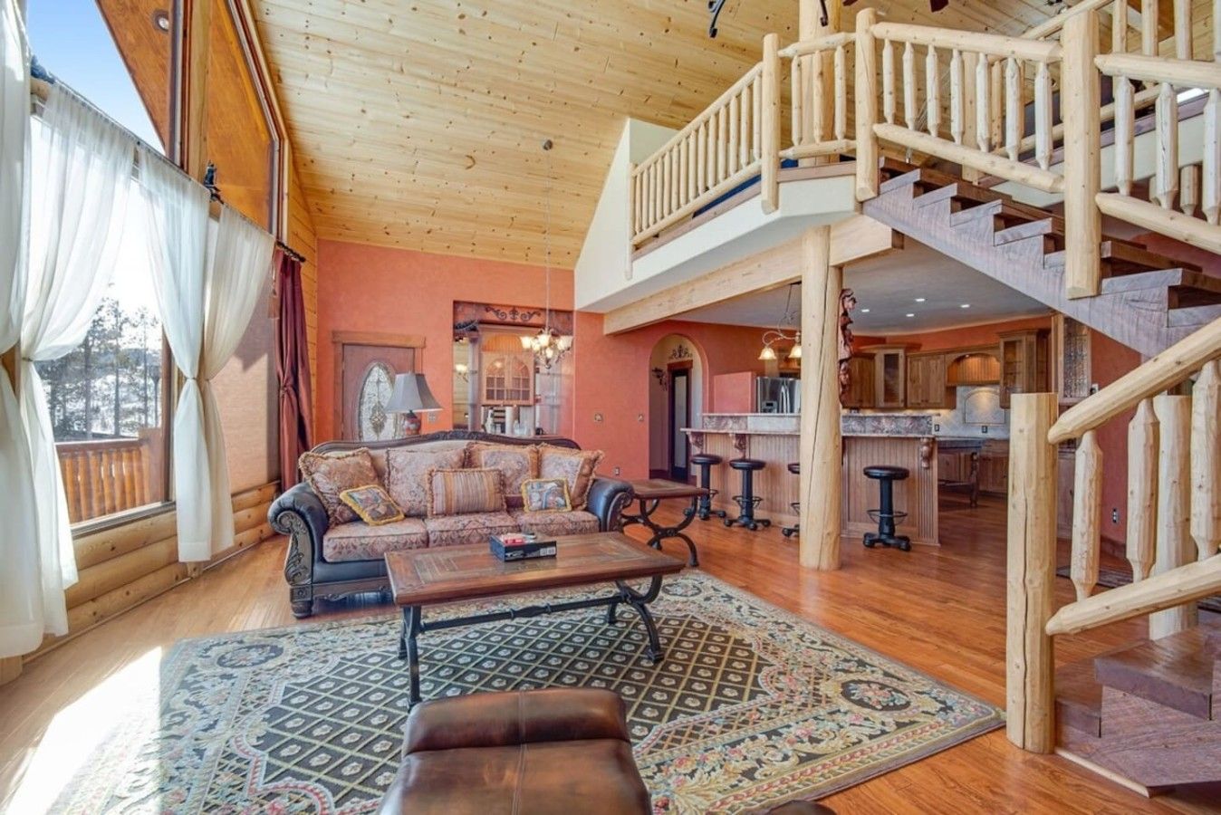A spacious living area with a wooden staircase, a sofa set, and a coffee table.