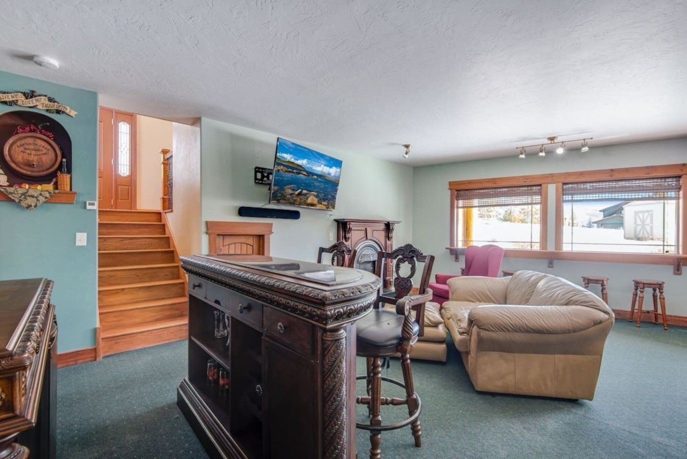 A living room with a sofa, a wooden cabinet, a fireplace, and a staircase.