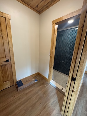Rustic-modern bath entry with wood accents and sleek tiled shower - The Twilight at The Narrows Cabins (Marshall)