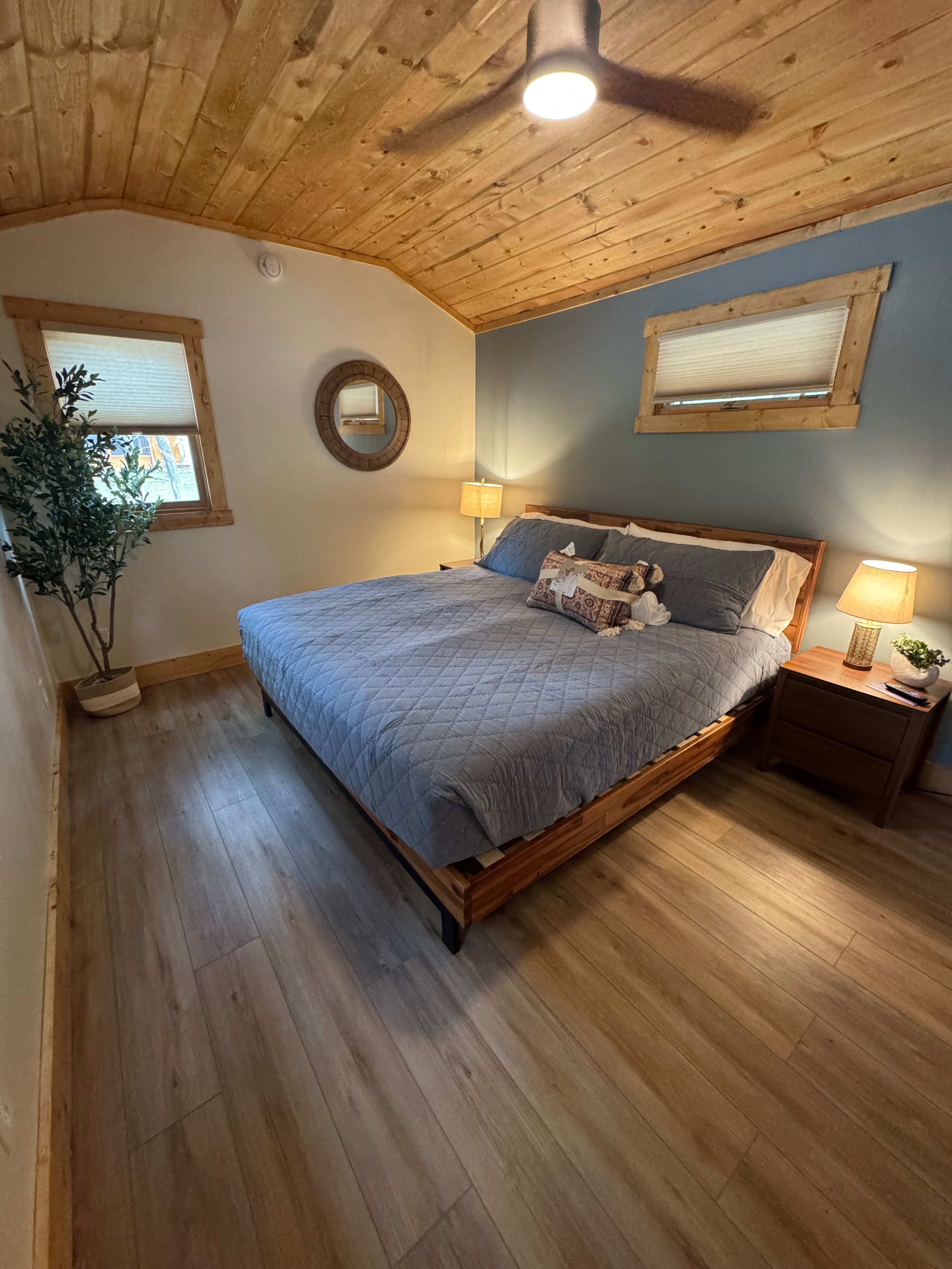 Cozy rustic bedroom with vaulted wood ceiling and warm bedside lighting