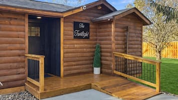Charming log cabin entry with covered porch and easy-access ramp